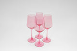 Four translucent bubblegum pink stemless wine glasses arranged in a close cluster on a white surface with a soft shadow beneath them.