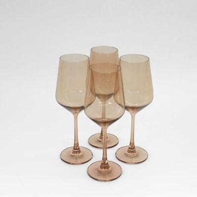Brown Sugar colored wine glass with golden amber ombré effect shown amongst natural decor