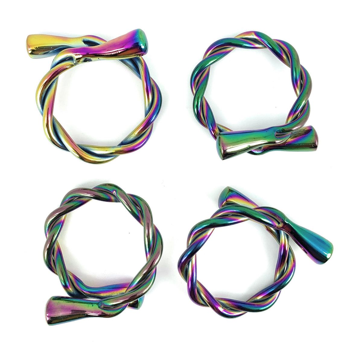 Set of four twisted metal napkin rings with a rainbow-colored, iridescent finish, each with a smooth cylindrical end piece against a white background.
