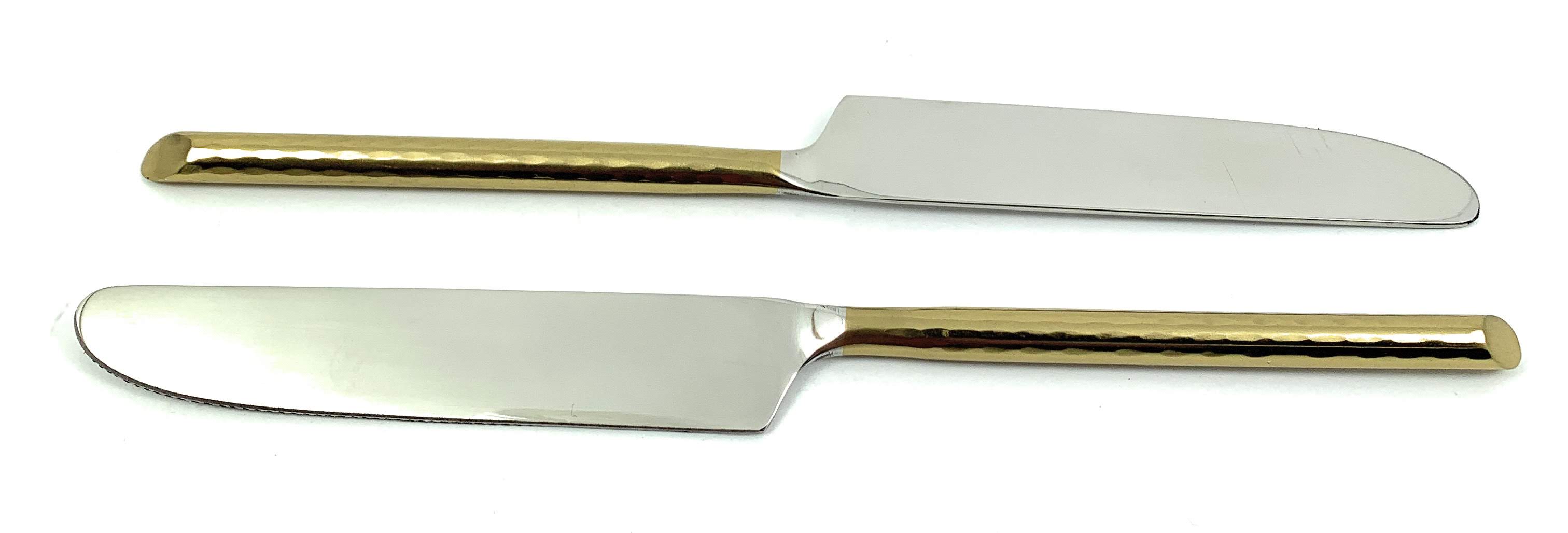 Set of six Vibhsa golden dinner knives arranged on a dark table surface
