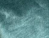Close-up of teal velvet fabric showing soft, plush texture with subtle variations in shading and a smooth, dense pile.