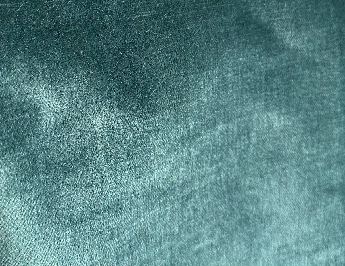Close-up of teal velvet fabric showing soft, plush texture with subtle variations in shading and a smooth, dense pile.