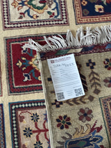 Hand-knotted Afghani Bakhteiari wool rug with floral and geometric motifs in red, beige, green, and navy, featuring knotted fringe and product label on the corner.