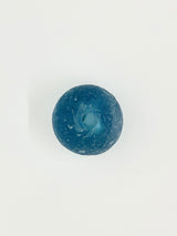 Small, round, textured bead in deep blue with a central hole, displayed against a white background.