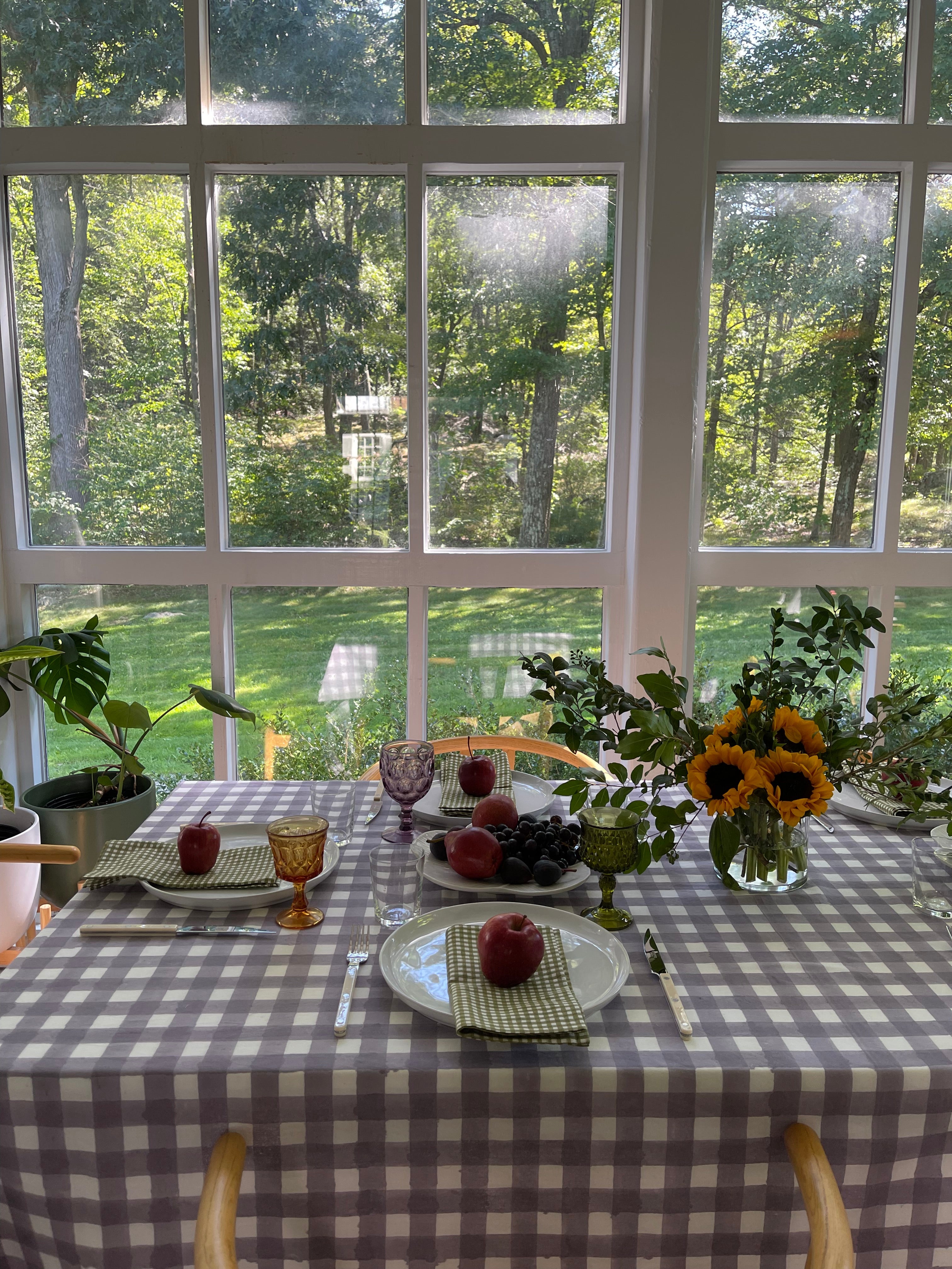 Lavender Gingham Tablecloth laid over a dining table with a dining setting