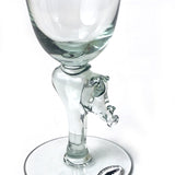 Clear glass wine glass with a stem shaped like a detailed animal head, resembling a horse or unicorn, on a round base against a white background.