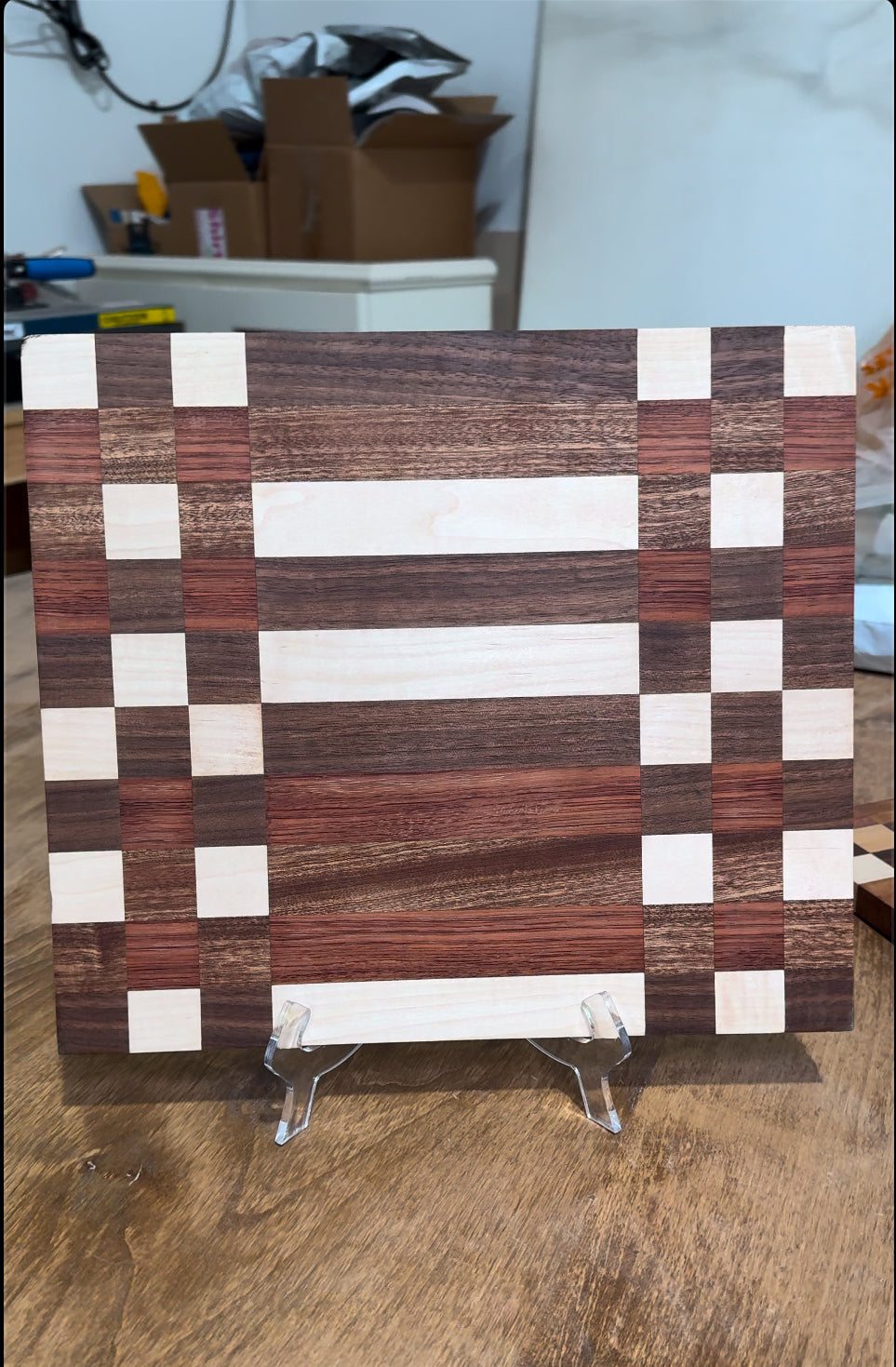 Handmade hardwood cutting board with rich wood grain and smooth finish shown on kitchen counter.