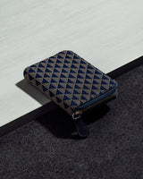 Rectangular coin purse with a navy and beige geometric UROKO pattern, featuring a zipper closure and rounded corners, placed on a two-tone surface.