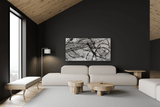 Modern living room with black accent wall featuring a large abstract black and white canvas above a minimalist white sofa, light wood coffee tables, and a floor lamp.