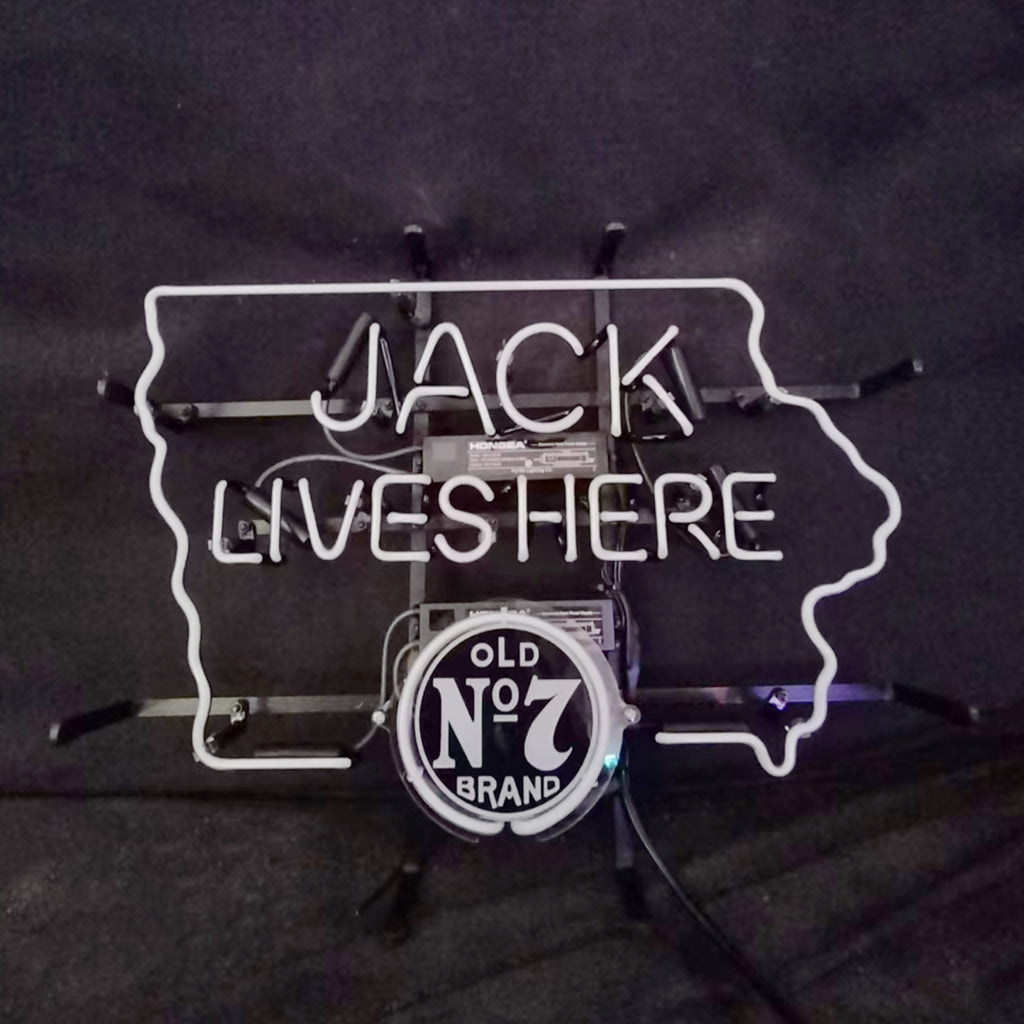 White neon sign shaped like the state of Iowa featuring text 'JACK LIVES HERE' and circular black and white 'OLD No 7 BRAND' logo in the center