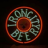Circular neon sign with red outer ring and light blue text reading 'IRON CITY BEER' surrounding a small circle featuring the Pittsburgh Steelers logo.