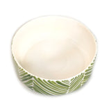 Round ceramic bowl with a white interior and exterior decorated with green palm leaf patterns, shown from an angled top view.