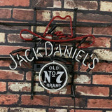 Neon sign featuring a red outlined cowboy hat and the text 'Jack Daniel's' in white, with a circular black and white 'Old No 7 Brand' emblem below, mounted on a brick wall.