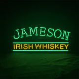 Neon sign with green text 'JAMESON' above yellow text 'IRISH WHISKEY' on a black background