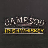 Neon sign with the word 'JAMESON' lit in white above 'IRISH WHISKEY' lit in yellow against a dark background.
