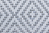 Close-up of a woven cotton textile with geometric diamond patterns in white and light grey shades, featuring a textured grid-like weave.