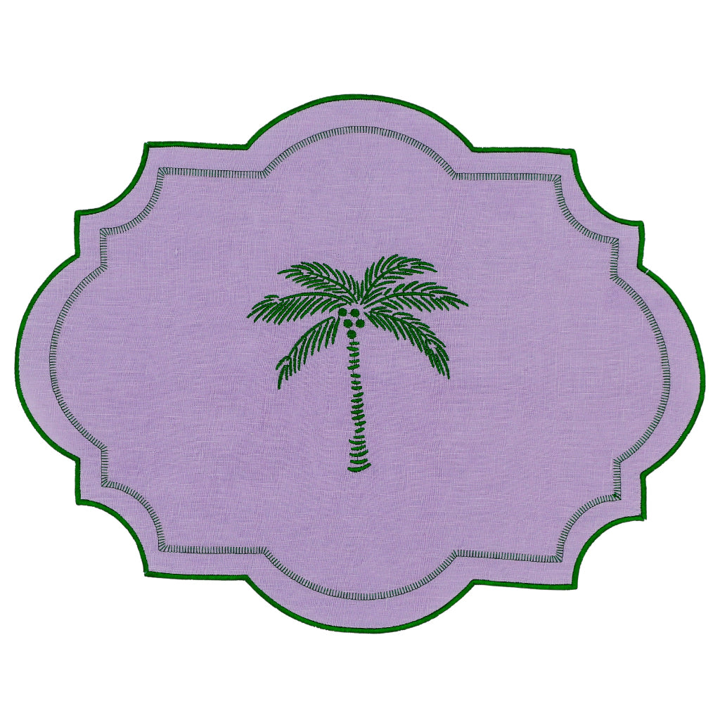 Set of four lilac linen placemats edged with emerald green embroidery featuring a palm tree motif