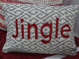 Rectangular cushion with gray and white geometric pattern background and the word 'Jingle' in large red letters across the center.