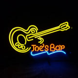 Neon sign depicting a yellow guitar outline above the orange text 'Joe's Bar' with a blue underline, set against a black background.