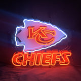 Neon sign with a glowing white arrowhead outline, red stylized KC letters inside, and red CHIEFS text below on a dark background.
