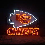 Neon sign featuring the KC Chiefs arrowhead logo outlined in white with 'KC' in orange inside and the word 'CHIEFS' glowing below in bold orange letters on a black background.
