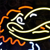 Bright neon sign depicting a stylized bird head with yellow beak, white eye, and red and orange feathers set against a dark background.