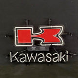 Neon sign with a red stylized 'K' logo above the white neon cursive lettering spelling 'Kawasaki' on a black background.