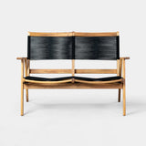 Wood-framed bench with a minimalist design featuring black woven straps on the backrest and seat, with natural wood armrests and legs against a plain background.