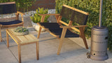 Outdoor wooden sofa bench with black woven seat and backrest next to matching wooden armchair and small rectangular wooden table on patio.