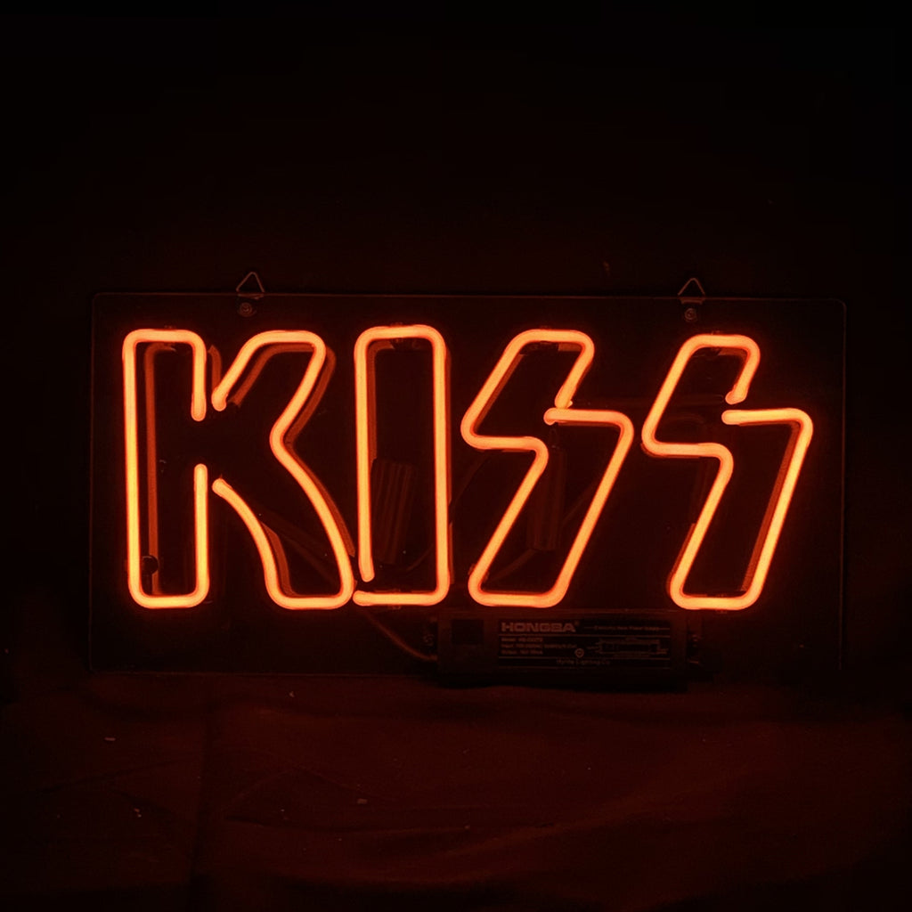 Rectangular neon sign glowing orange-red that spells KISS with two stylized lightning bolt 'S' letters against a dark background.