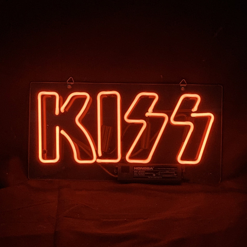 Kiss Neon Sign with pink luminous lettering on acrylic backing