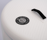 Close-up of a white inflatable tub showing a gray circular valve with black surrounding text and a black fabric handle attached nearby on textured surface.