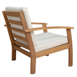 Side view of a wooden armchair with light beige cushions and horizontal slats on the backrest, featuring slightly curved armrests and sturdy legs.