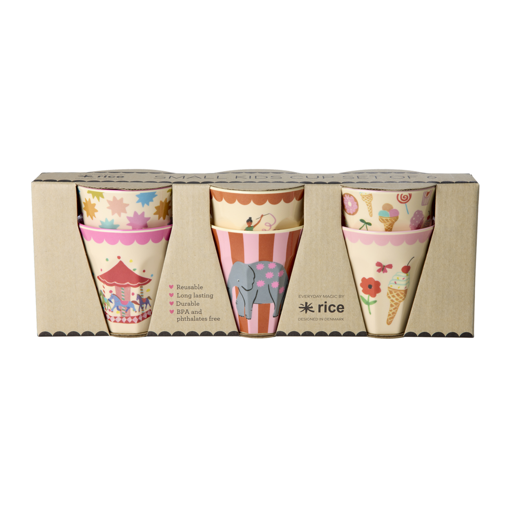 Set of six pink melamine kids cups with fun fair prints arranged on a white surface
