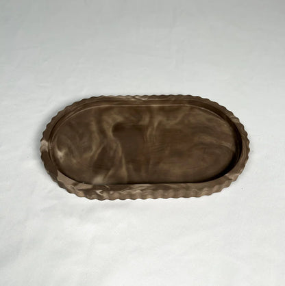 Brown ceramic tray with decorative edge on a white background