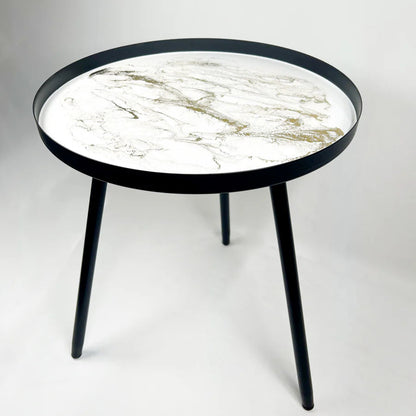 Round resin table with marble-patterned top and black frame on a white background