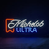 Neon sign with 'Michelob' in white cursive script and 'ULTRA' in blue block letters, accented by a red banner graphic on the left side.