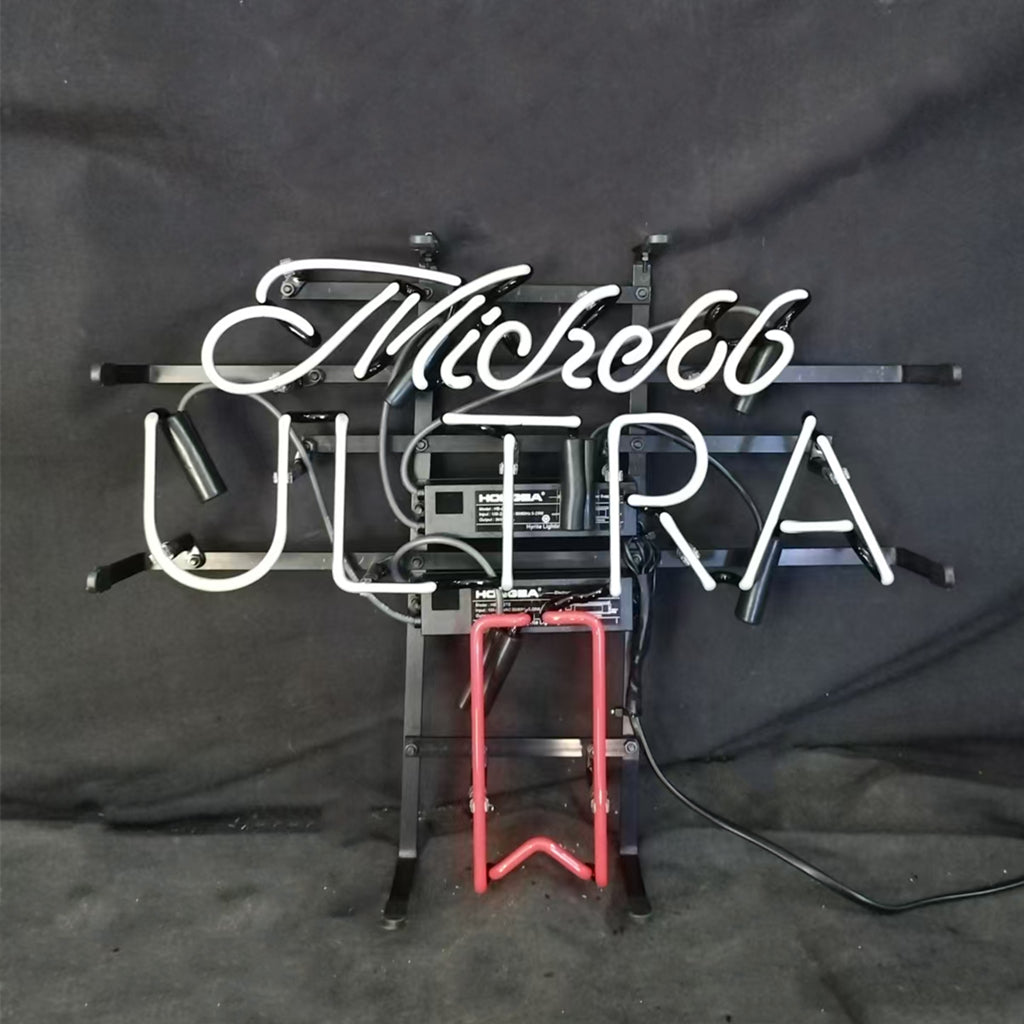 White neon script spelling 'Michelob' and block letters 'ULTRA' with a red neon outline below, mounted on black metal and wiring against a dark background.