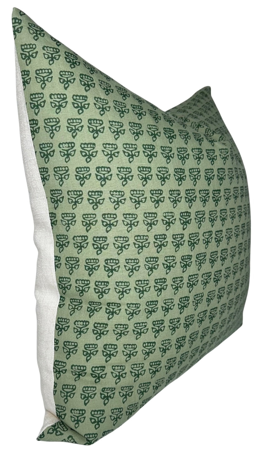 Green rectangular pillow with a repeating dark green floral pattern and white fabric on the side edges, angled to show front and side.