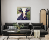 Square canvas print of a cow's head in expressive brushstrokes with cream, brown, and green hues, hung above a modern dark gray sofa with cushions.