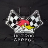 Neon sign with cartoon woodpecker between two black-and-white checkered flags above white neon text reading 'HOT ROD GARAGE' on a black background.