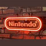 Red neon Nintendo logo sign hanging on a dark brick wall with black mounting brackets and a visible electric cord.
