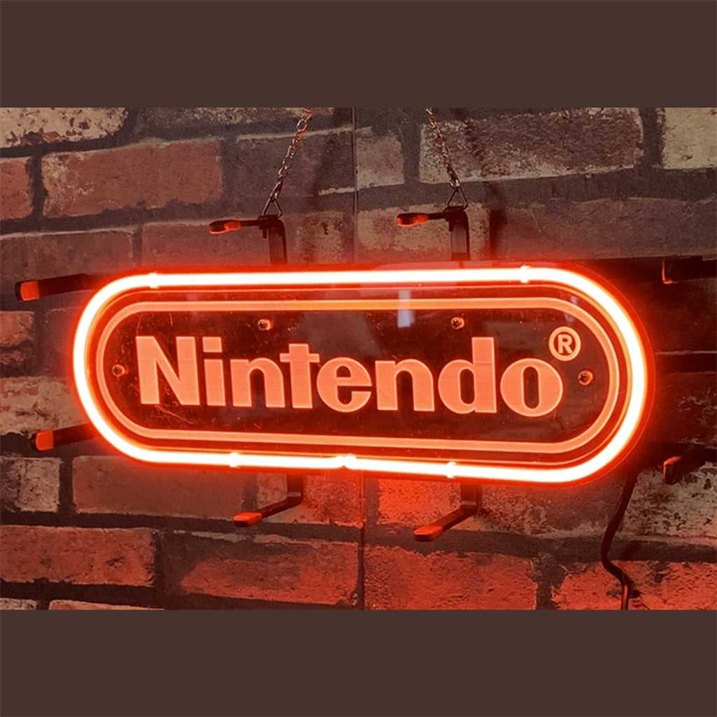 Red neon Nintendo logo sign hanging on a dark brick wall with black mounting brackets and a visible electric cord.