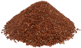 Pile of reddish-brown granular mineral and vitamin supplement with uneven small particle sizes on a white background.