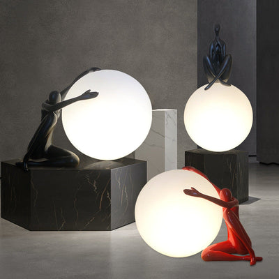 Orb Modern Sculpture Lamp in black and red resin finish, spherical design emitting soft ambient light