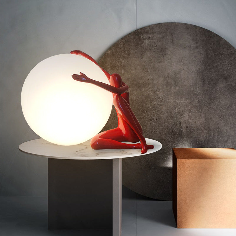 Orb Modern Sculpture Lamp in black and red resin finish, spherical design emitting soft ambient light