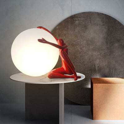 Orb Modern Sculpture Lamp in black and red resin finish, spherical design emitting soft ambient light