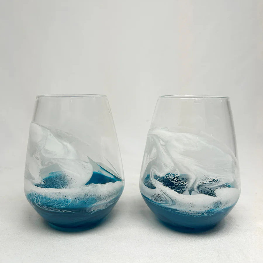 Two resin glass tumblers with blue and white ocean wave design on a white background