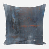 Square pillow with abstract design in dark blue and rusty orange tones, featuring textured, weathered patterns
