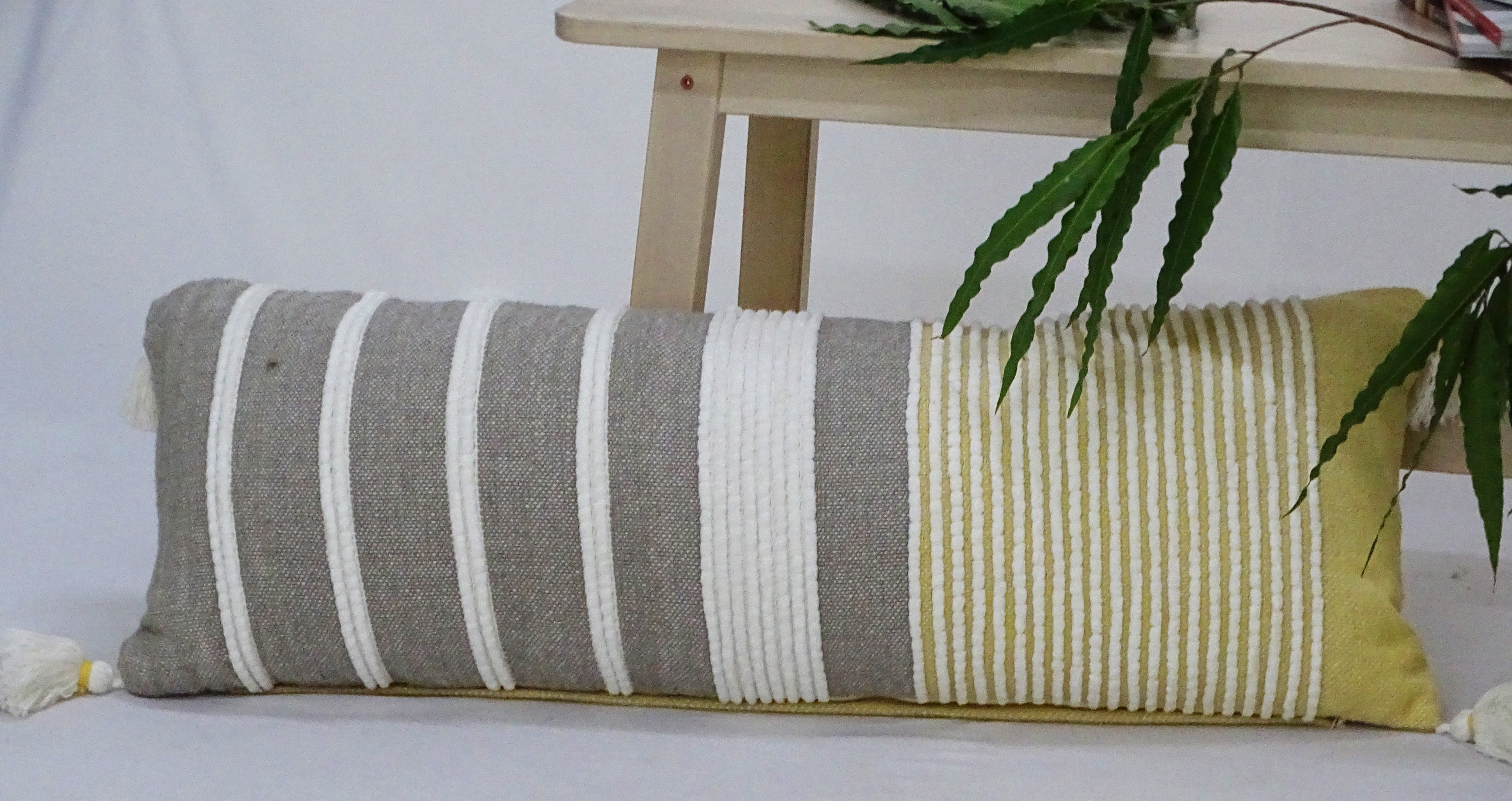 Decorative Long Grey Stripes Throw Pillow in grey, white, and ocher stripes on a sofa